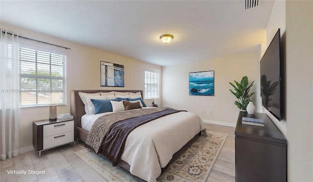 bedroom featuring baseboards and visible vents