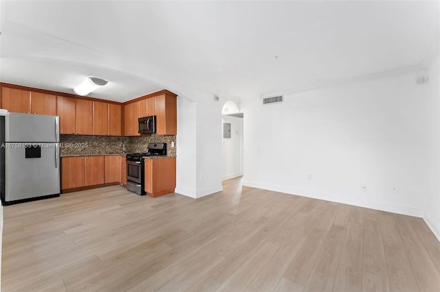 kitchen with visible vents, decorative backsplash, brown cabinets, stainless steel appliances, and light wood-type flooring