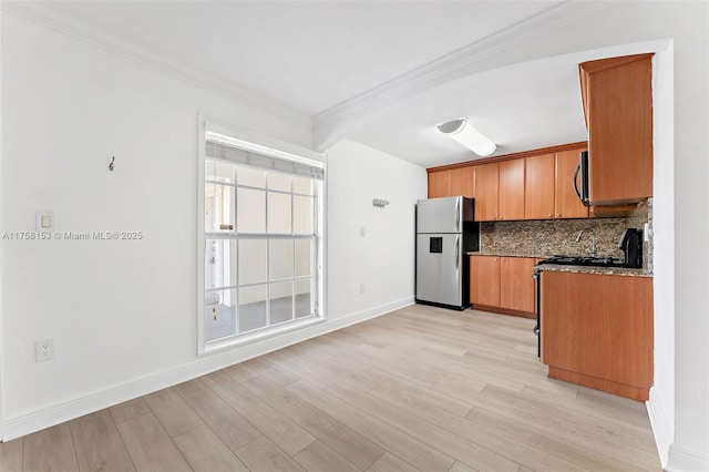 kitchen with stainless steel appliances, decorative backsplash, brown cabinetry, light wood-type flooring, and baseboards