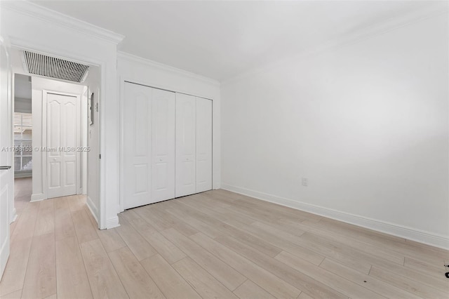 unfurnished bedroom featuring ornamental molding, light wood-type flooring, visible vents, and baseboards