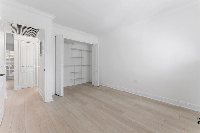 unfurnished bedroom with a closet, visible vents, light wood-style flooring, and baseboards