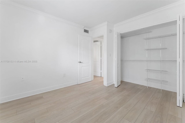 unfurnished bedroom featuring visible vents, baseboards, light wood-style floors, ornamental molding, and a closet