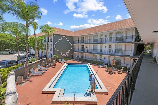 community pool with fence and a patio area