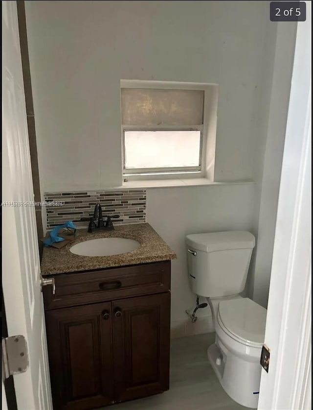 bathroom featuring toilet, tasteful backsplash, and vanity