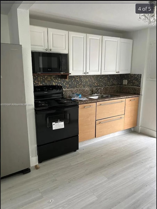 kitchen with tasteful backsplash, light wood-type flooring, black appliances, white cabinetry, and a sink