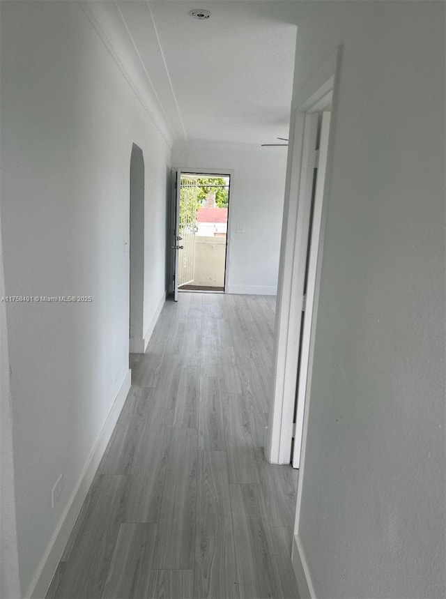 hall with baseboards and wood finished floors