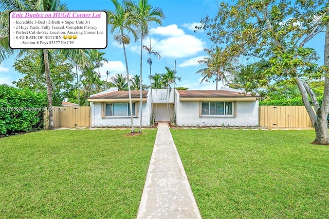 single story home featuring brick siding, a gate, fence, and a front yard