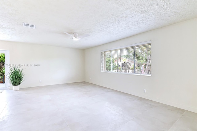 spare room with a healthy amount of sunlight, visible vents, and a textured ceiling