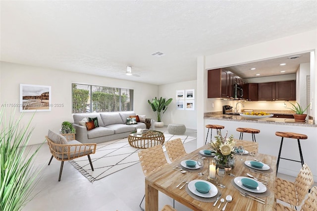 interior space with visible vents, ceiling fan, and a textured ceiling