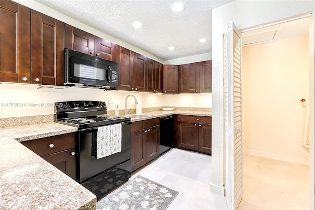 kitchen with light countertops, a sink, a textured ceiling, and black appliances