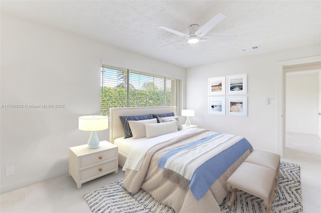 bedroom featuring a ceiling fan, visible vents, and a textured ceiling