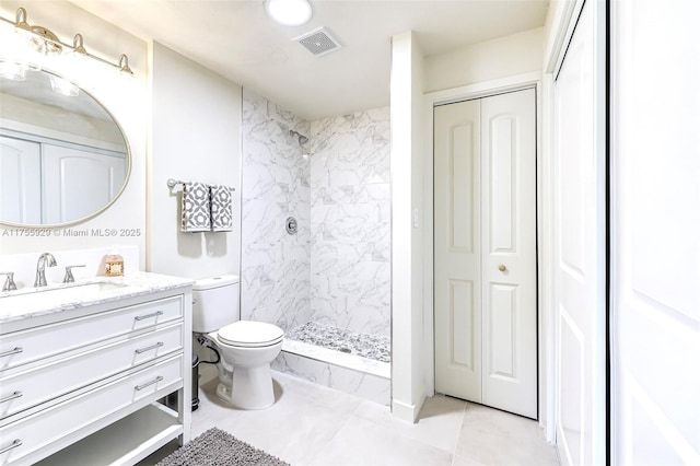 full bath featuring toilet, vanity, visible vents, a closet, and a tile shower