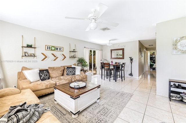 living area featuring baseboards, light tile patterned flooring, visible vents, and a ceiling fan