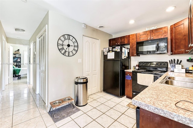 kitchen with light tile patterned floors, recessed lighting, a sink, light countertops, and black appliances