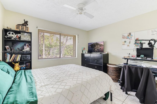 bedroom featuring light tile patterned flooring, ceiling fan, and a textured ceiling