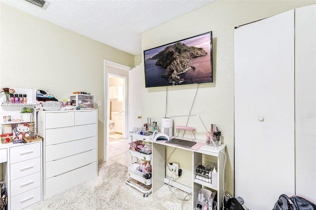 carpeted office space with visible vents and a textured ceiling