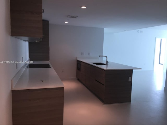 kitchen featuring visible vents, modern cabinets, black electric cooktop, a sink, and recessed lighting