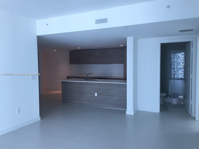 kitchen with visible vents, a sink, baseboards, and modern cabinets