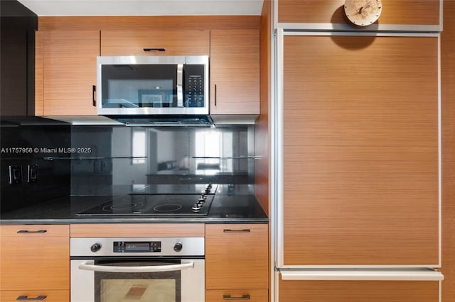 kitchen featuring dark countertops, tasteful backsplash, and appliances with stainless steel finishes