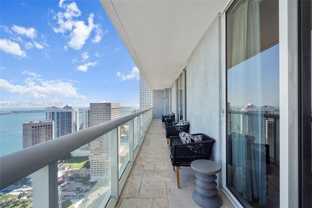 balcony featuring a water view and a city view