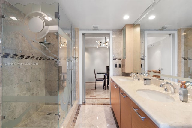 full bathroom featuring a stall shower, double vanity, a sink, and recessed lighting