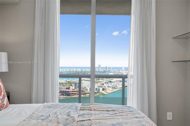 bedroom with a water view and a city view