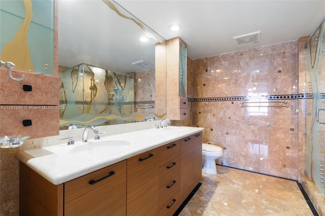 bathroom featuring visible vents, a stall shower, a sink, and tile walls