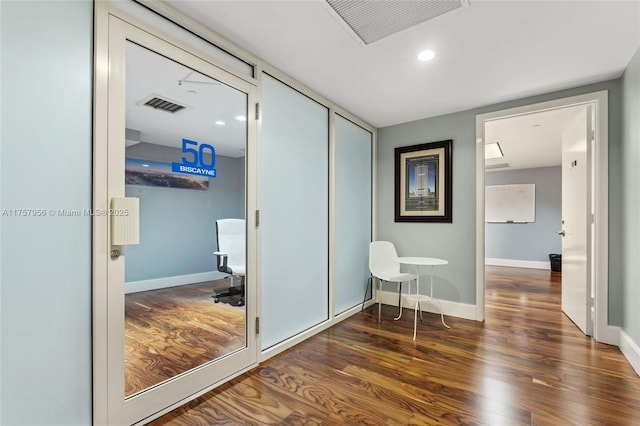 hall with recessed lighting, wood finished floors, visible vents, and baseboards