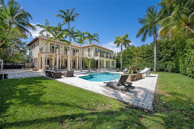 pool featuring a patio area, fence, and a lawn