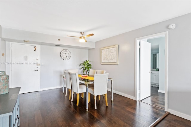 dining room with dark wood-type flooring, a ceiling fan, and baseboards