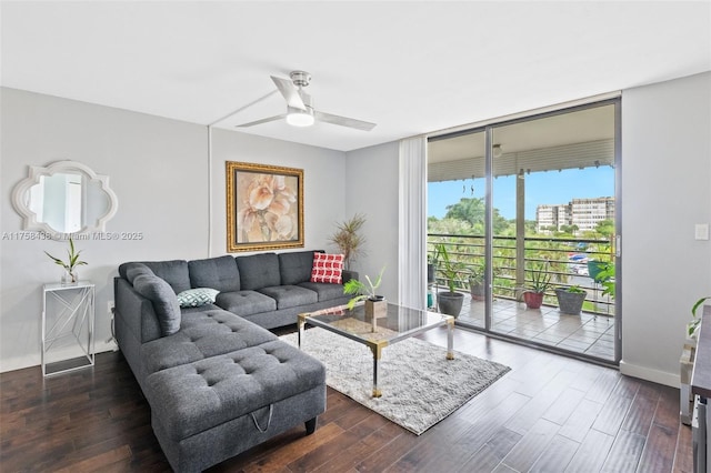 living area featuring a view of city, ceiling fan, wood finished floors, a wall of windows, and baseboards