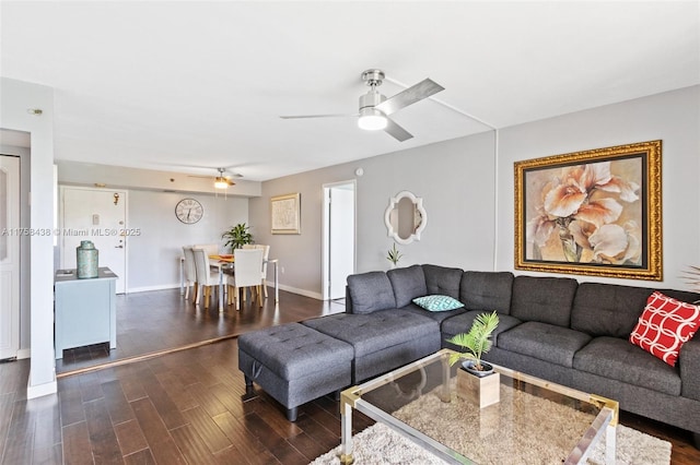 living area featuring dark wood-style floors, ceiling fan, and baseboards