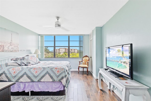 bedroom featuring ceiling fan, wood finished floors, and baseboards