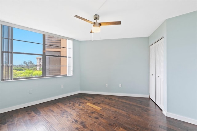 unfurnished bedroom featuring a closet, baseboards, and hardwood / wood-style flooring