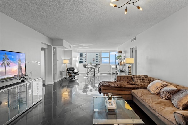 living room featuring a textured ceiling, tile patterned flooring, visible vents, and baseboards