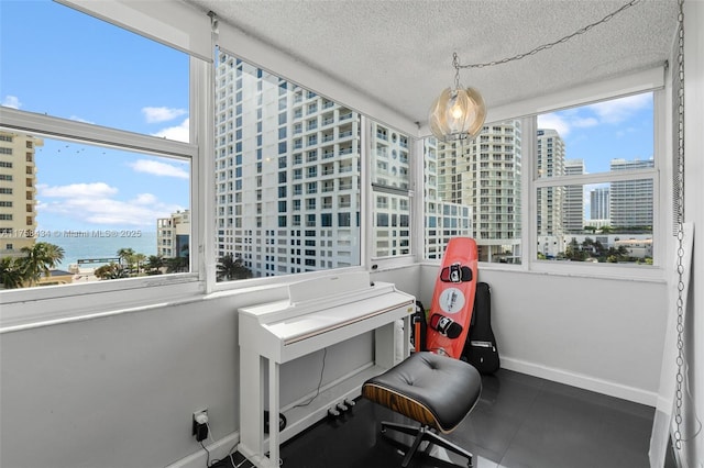 office with a wealth of natural light, a view of city, a textured ceiling, and baseboards