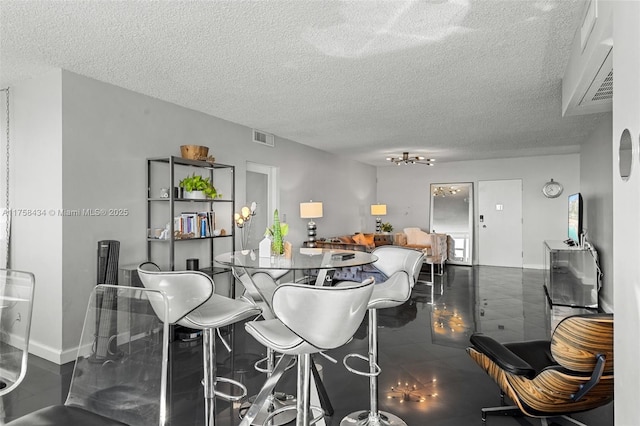 dining room featuring baseboards, visible vents, and a textured ceiling