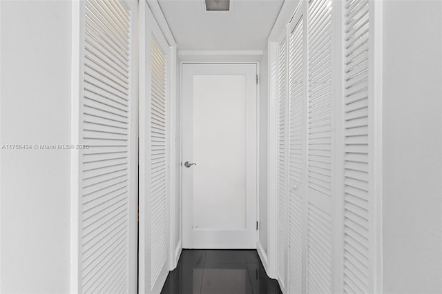 hallway featuring dark tile patterned flooring