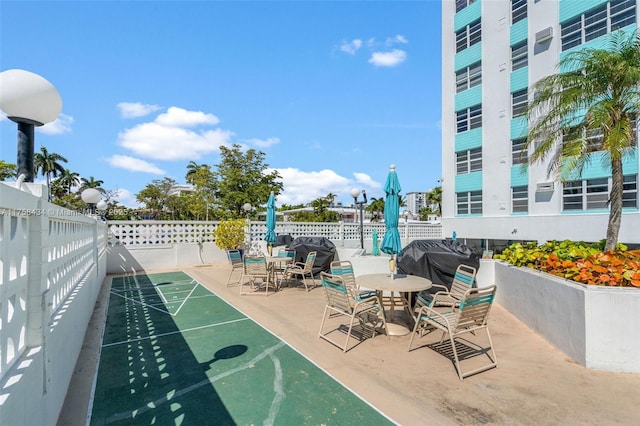 view of property's community featuring shuffleboard and fence