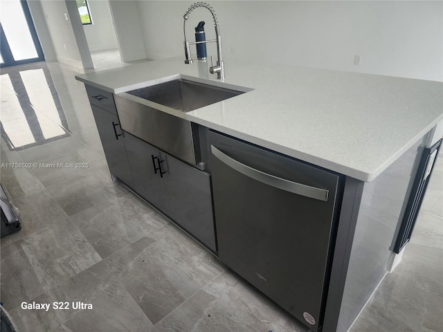 kitchen with marble finish floor, a center island with sink, stainless steel dishwasher, a sink, and modern cabinets