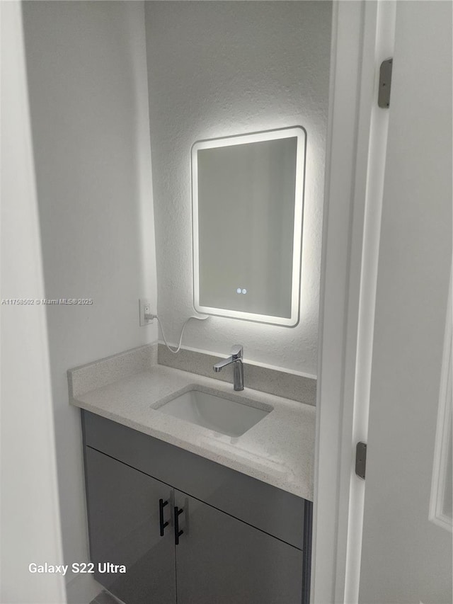 bathroom featuring a textured wall and vanity