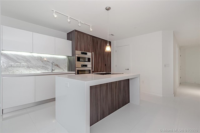 kitchen featuring double oven, a sink, white cabinets, light countertops, and tasteful backsplash