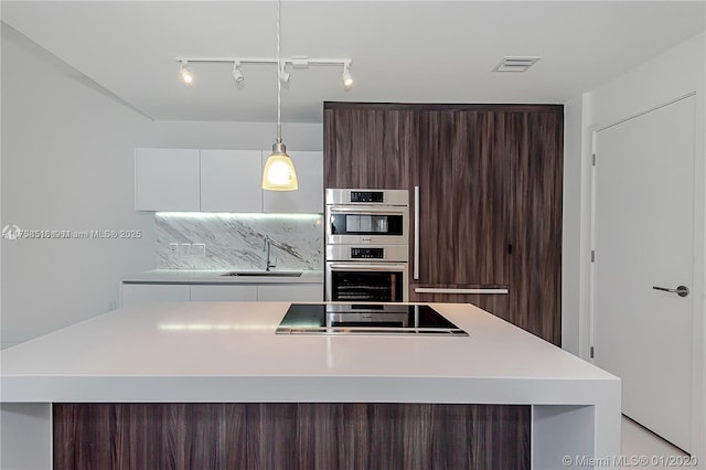 kitchen with visible vents, double oven, a sink, dark brown cabinets, and modern cabinets