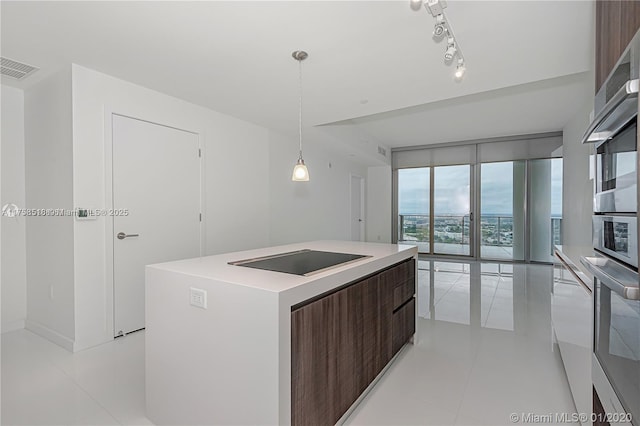 kitchen with black electric stovetop, floor to ceiling windows, visible vents, a center island, and modern cabinets