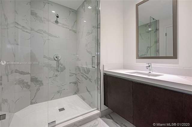 bathroom featuring marble finish floor, a marble finish shower, and vanity