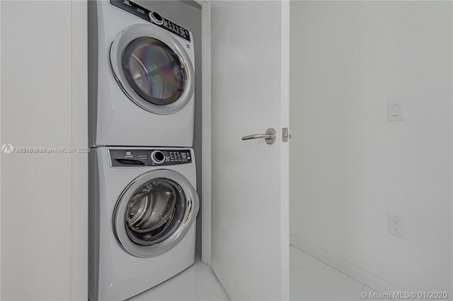 washroom with laundry area, stacked washer / drying machine, and light tile patterned flooring