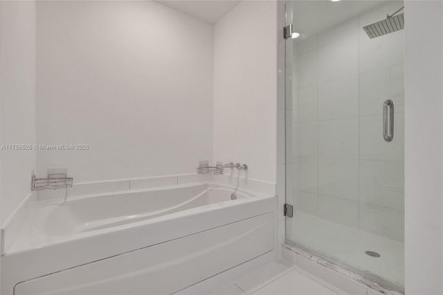 bathroom featuring tile patterned floors, a garden tub, and a shower stall