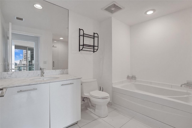 bathroom featuring visible vents, a garden tub, vanity, and toilet