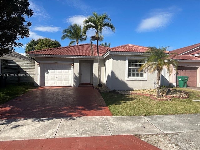 view of front facade with a garage, driveway, a tile roof, and stucco siding