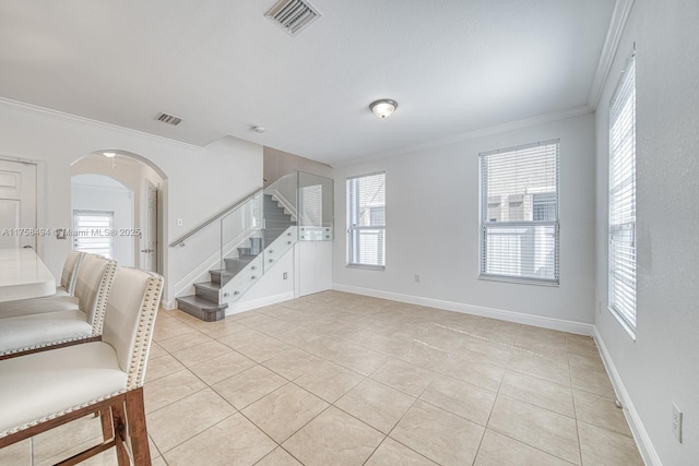 interior space featuring arched walkways, light tile patterned floors, visible vents, stairs, and ornamental molding